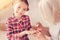 Mindful grandmother painting nails of her stylish granddaughter