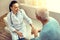 Mindful medical worker listening to thankful elderly patient