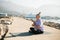 Mindful senior woman with dreadlocks meditating by the sea and beach copy space - wellness and yoga practice