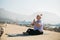 Mindful senior woman with dreadlocks meditating by the sea and beach copy space - wellness and yoga practice