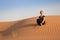 Mindfulness. A woman in harmony, contemplates in sand dunes during sunset.