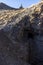 Mine shaft dug into a hill at the bottom of the mountain below a wooden headframe