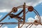 Mine shaft pulley structure with blue sky and clouds behind