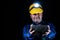 A miner holds a large lump of coal in his hands. A helmet with a lit flashlight on the miner& x27;s head