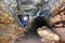 Miner man underground in a mine tunnel. Worker in overalls, safety helmet