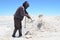 A miner shovels salt from the Salar de Uyuni, the world`s biggest salt flats. Uyuni, Bolivia