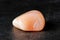 Mineral pink agate on a black concrete background. The concept of using minerals and crystals in astrology and