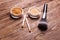 Mineral powder of different colors with a spoon dispenser for make-up on wooden background