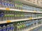 Mineral water is packaged in plastic bottles and labeled with various brands. Displayed on a shelf inside a supermarket.