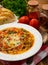 Minestrone- italian soup with vegetables on brown wooden table.