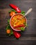 Minestrone soup on dark wooden table with vintage spoon and vegetables