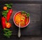 Minestrone soup in red bowl with vintage spoon on old darkt wooden table