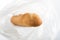 Mini baguette long loaf pastries in a transparent bag on a white background