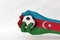 Mini ball of football in Azerbaijan flag painted hand on white background. Blue red and green with crescent and star.