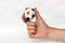 Mini ball of football in hand and one black point of football is Cameroon flag, hold it with two finger on white background