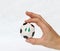 Mini ball of football in hand and one black point of football is Nigeria flag, hold it with two finger on white background