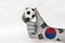 Mini ball of football in South Korea flag painted hand, hold it with two finger on white background.