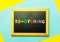 Mini blackboard written Re Opening over multi-colored background