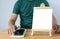 A mini blank whiteboard on  wooden table with man and Smartphone