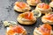 Mini blini pancakes with soft cheese, cold smoked salmon and dill