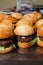 Mini burger on a stand close-up. Children fast food in a restaurant or cafe. Macro photo of burger ingredients with meat and