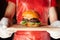 Mini burger on a stand close-up. Children fast food in a restaurant or cafe. Macro photo of burger ingredients with meat and