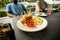 Mini burgers on white plate on black cafe table