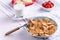 Mini cereal pancakes in blue bowl with fork, strawberries, glass of milk on white background, rural Breakfast concept