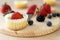 Mini cheesecake decorated with blueberry, blackberry and strawberry