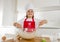 Mini chef girl with cook hat and apron mixing flour and eggs baking preparing sweet desert smiling happy