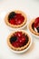 Mini cherry pies/tarts on plates garnished with blackberry