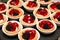 Mini cherry pies/tarts on plates garnished with blackberry