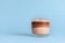 Mini cup of multilayer coffee in a glass cup on blue background