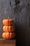 Mini decorative pumpkins against a rustic wood background