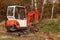 Mini excavator on a building site. Excavation work. The excavator works in the garden.