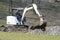 A mini excavator digs a ditch for laying pipes