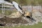 A mini excavator digs a ditch for laying pipes