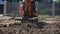 A mini excavator with a rake loosens the ground. landscape preparation.