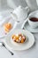 Mini fruits tart dessert with orange slice and meringue and cup of tea on the table