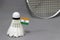 Mini India flag stick on the white shuttlecock on the grey background and out focus badminton racket