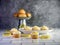 Mini lemon cupcakes with a rustic metal display filled with artificial lemons and artificial lemon slices arranged between the