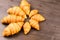 Mini and maxi croissants lying on wooden table