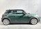 Mini modern car in racing green color side view in dealership interior of cooper