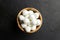 Mini mozzarella cheese balls in wooden bowl on black stony background