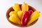 Mini multicolored peppers, in wooden cup, on white background