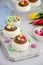 Mini Pavlova Birds Nest with chocolate cream and colored candy on a board on a light background. Merengue Cookies.