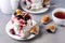 Mini Pavlova Cake with Figs and Berry Tasty Dessert Pavlova on White Plate White Cup of Tea and White Teapot Gray Background