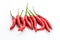 Mini pods of red chili peppers hot additive to meat and chicken giving flavor to a group of vegetables on a white background