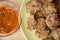 Mini pork patties, meatballs with bread, tomato sauce and fork on wood