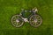 Mini retro blue toy bike on grass meadow